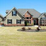 Elegant suburban family house with large lawn and driveway, ideal for real estate listings.